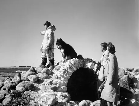 Inuk guide, Husky sled dog and tourist couple