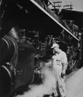 Railway employee oiling moving parts on locomotive