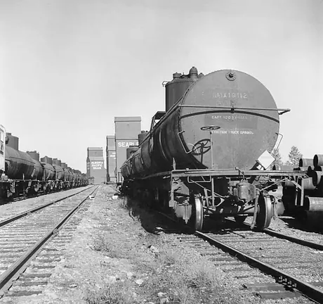 Oil tank cars and grain elevators on the prairies