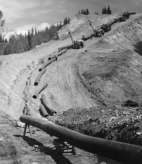 Segments of pipe being placed alongside the trench