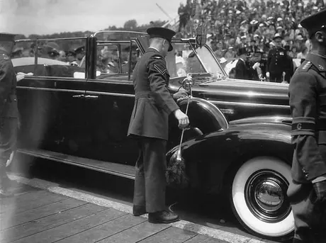 A chauffeur dusts and polishes the Royal Tour car during the 1939 Royal Tour of Canada