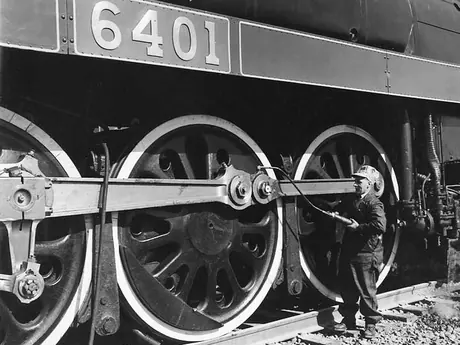 A Mechanist greasing engine parts on Canadian National Railways steam locomotive no. 6401