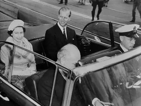 Queen Elizabeth and Prince Philip ride in an open touring car during the Royal visit to Ottawa in 1957