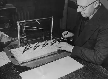 Canadian National Railways official using a signograph machine to sign cheques
