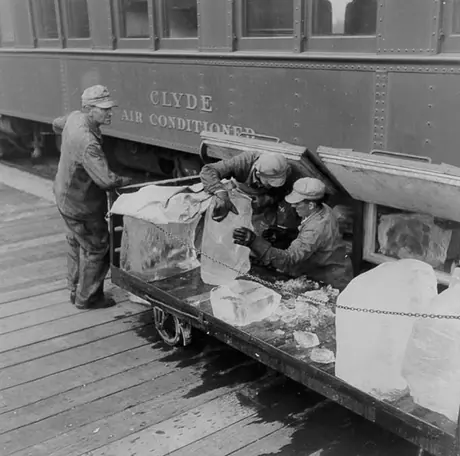 Loading blocks of ice into the air-conditioning unit of a Canadian National Railways passenger coach