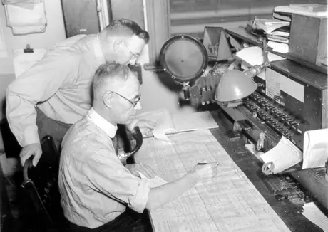 CN employees examining train dispatch sheets
