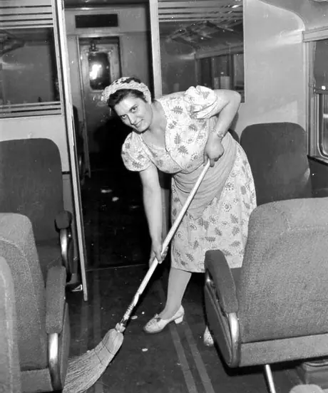 CN employee sweeping the interior of a passenger car