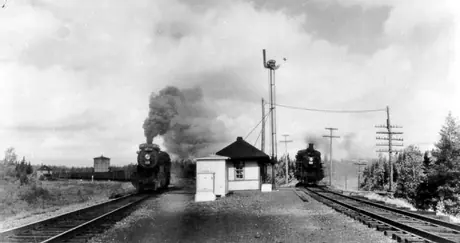 Two steam locomotives passing by centralized traffic control station