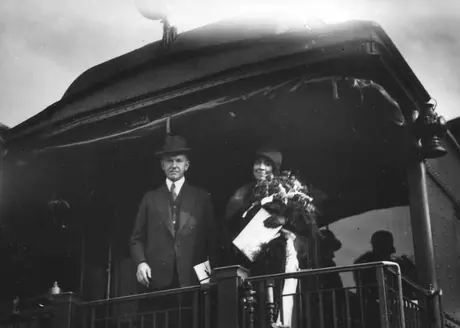 United States President and Mrs. Calvin Coolidge standing on the open platform of a business car