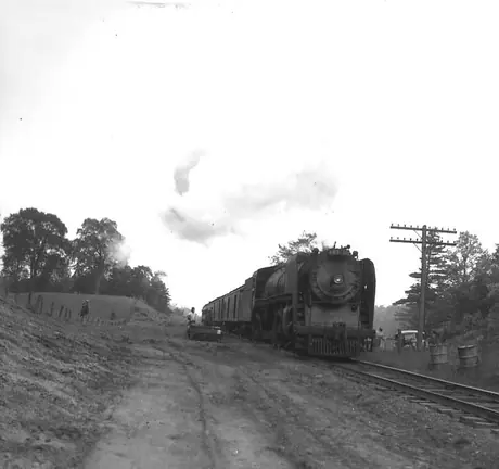 A Central Vermont Railway passenger train headed by U-1-a steam locomotive 603 passes a track work site.