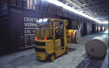 Loading rolls of QNS Paper Co. Ltd. Newsprint into Central Vermont Railway boxcars.
