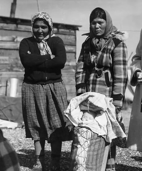 Two Cree women with child in cradleboard