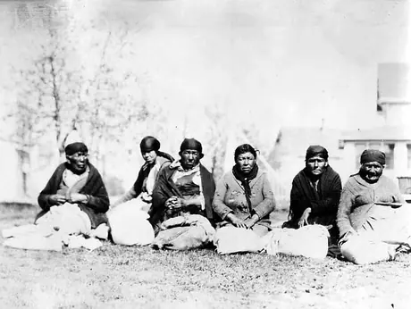 Seven Northern Aboriginal women sitting on the grass
