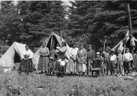 Ojibwa women and children lined up outside their prospector-type tents
