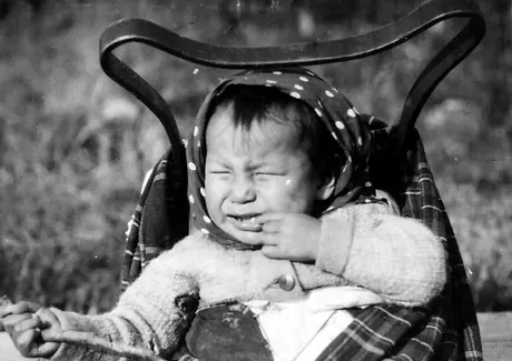 Ojibwa baby in cradleboard, crying