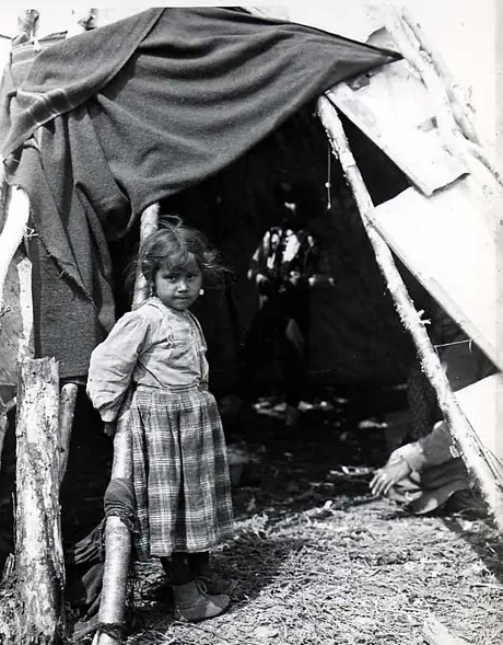 Ojibwa girl at entrance to birch bark wigwam