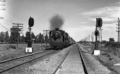 Steam locomotive U-2-h 4-8-4 6239 with a freight train passing signals.