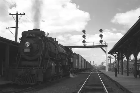 Steam locomotive S-3-a 3702 with a freight train, with signals on an arch.
