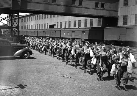 Troops marching from train to ship en route overseas
