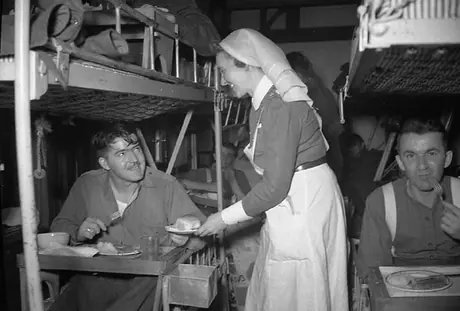 Nursing sister serving lunch to wounded soldiers aboard the hospital ship Lady Nelson