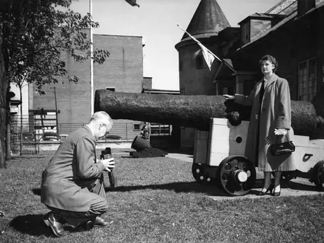 Woman posing for a photograph by a cannon at Chateau de Ramzay