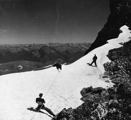 Mountain climbers helping a fallen comrade at the summit