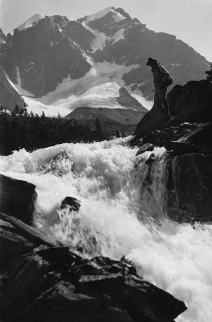 A hiker standing by a mountain stream, Fryatt area