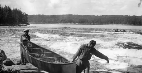 Two men portaging canoe at Victoria Rapids