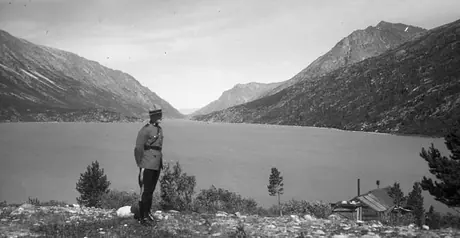 A member of the Royal Canadian Mounted Police standing near Lake Bennett