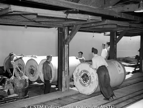 Moving rolls of newsprint off the conveyor belt, Bowater’s Newfoundland Pulp and Paper Mill
