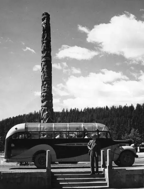 A Jasper Park Lodge tour bus, with a totem pole in the background