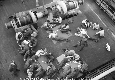 Troops taking a rest and playing games on deck the Lady Rodney