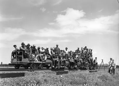The extra gang, on track motor cars, passing the surveying party working in advance of them lining up their work