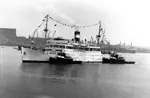 Passenger ship S.S. Lady Rodney with tugs in Boston Harbour