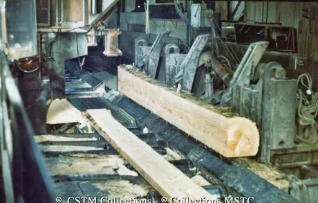 Debarking machine processing a log of wood
