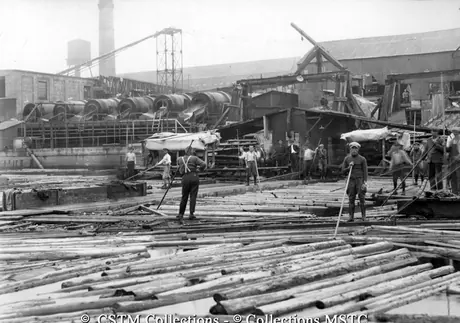 Employees of the Laurentide Pulp Mill directing logs into the mill