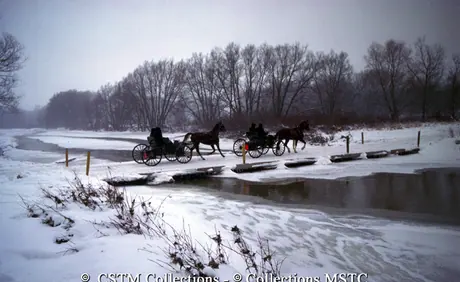 Mennonites in horse drawn buggies crossing the Conestoga River