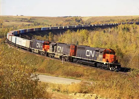 SD40-2 5034 and GP38-2 5532 and 5544 lead container train 208 east bound at Ennishore, NB in 1974