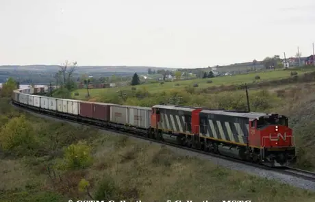 Diesel locomotives HP-616 2116 and 2115 built by Montreal Locomotive Works with a container train.  The class was the first built with a Draper Taper.