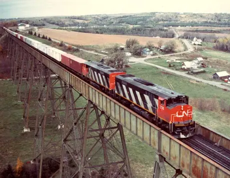 Diesel locomotives HP-616 2116 and 2115 built by Montreal Locomotive Works with a container train