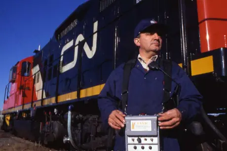 An engineer using a Belt Pack remote control device for diesel locomotives
