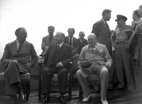 U.S. President Roosevelt; Canadian Prime Minister, Mackenzie King and British Prime Minister, Winston Churchill. On the wall seated is Anthony Eden, Brendan Bracken, and Harry Hopkin