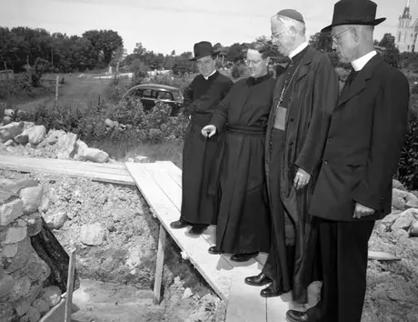 Rev. James McGivern, Archivist of the Jesuit Order, pointing out the 300 year old stones of the bastions to Archbishop Beckman and Rev. T.J. Lally