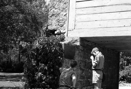 Tourists reading a plaque at the gate to Fort Garry