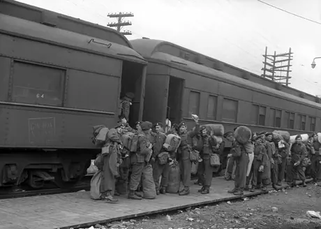 Troops returning from overseas board a troop train home